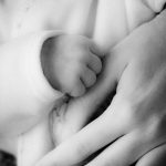 photo en noir et blanc de main de bébé et de son papa