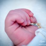 main de bébé rosie avec alliances de ses parents