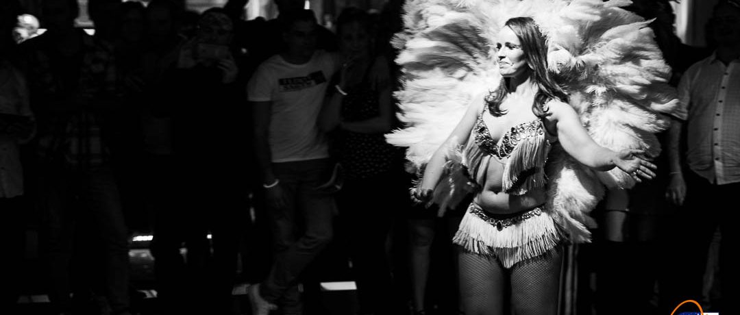 Photo de soirée sur le thème brésil, danseuse avec plumes dans la lumière, photo en noir et blanc